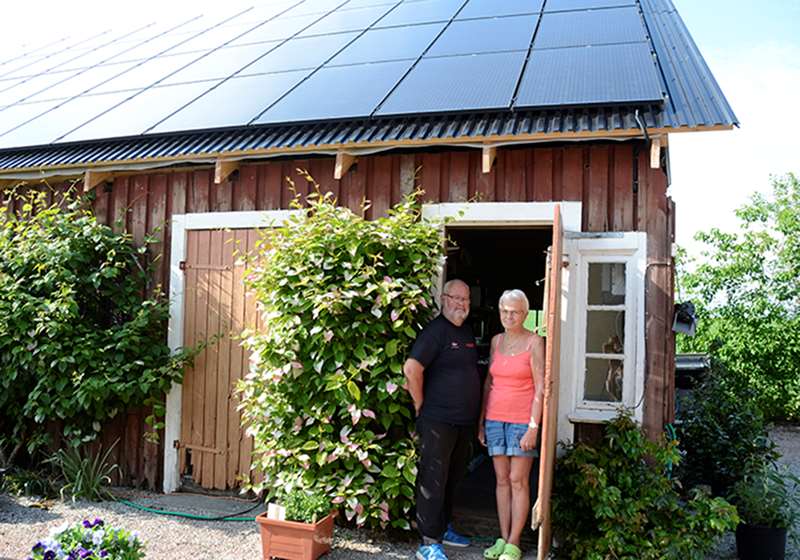 Husägare framför gamla stationshuset i Vennberg med solcellspaneler på taket
